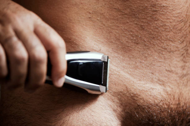 man trimming his pubes with an electric trimmer closeup of a young caucasian man in the bathroom trimming the hair of his pubes with an electric trimmer body hair stock pictures, royalty-free photos & images