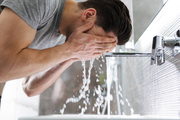 istock Side view of brunette man washes his in bathroom 1276394689