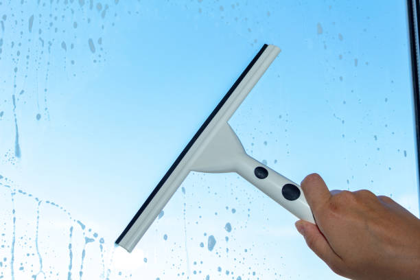 cleaning window with special brush on the the blue sky background
