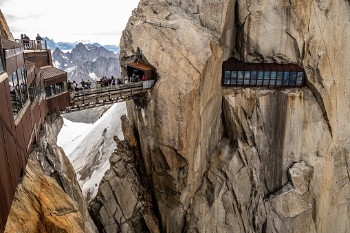 The Aiguille du Midi footbridge. The Aiguille du Midi is a 3,842-metre-tall mountain in the Mont Blanc massif within the French Alps. It is a popular tourist destination and can be directly accessed by cable car from Chamonix that takes visitors close to Mont Blanc.Chamonix needles, Mont Blanc, Haute-Savoie, Alps, France