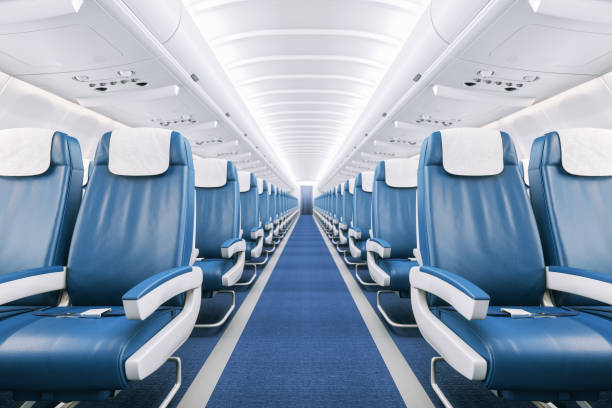 Airplane Interior Interior of a commercial airplane cabin with blue leather seats. passenger cabin stock pictures, royalty-free photos & images