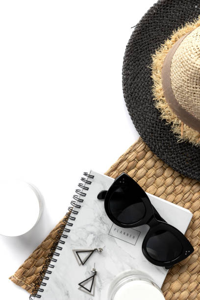 istock Creative composition with sunglasses, planner, cosmetics and straw napkin on white background. 1276399192