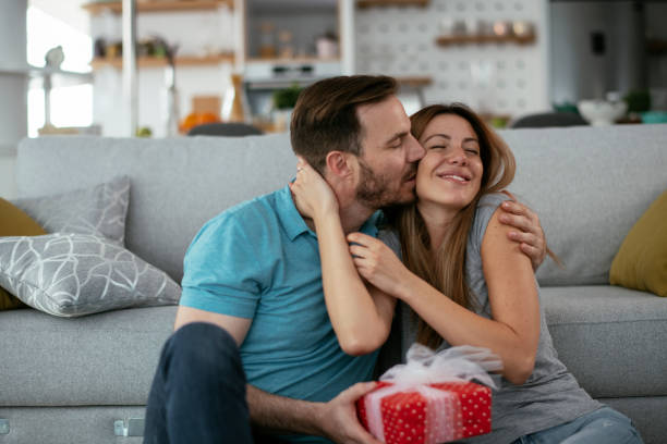 istock Young man giving gift box to his wife 1276399854