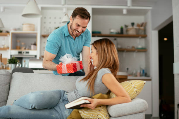 istock Young man giving gift box to his wife 1276400501