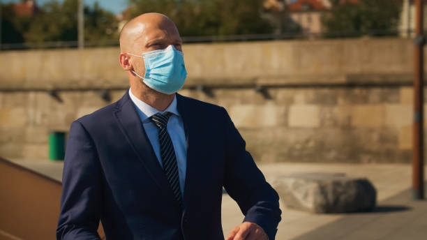 istock Businessman spending time on boulevards. Wearing mask for protection 1276402485