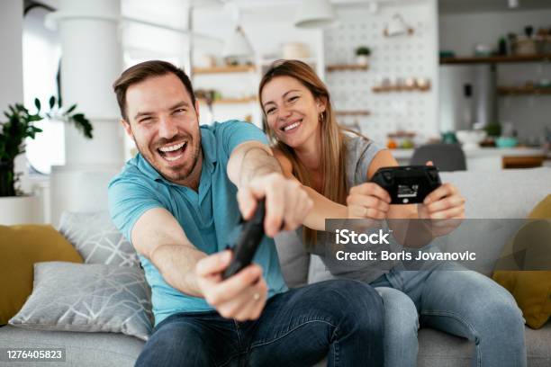 Boyfriend and girlfriend playing video games with controller on console  Stock Photo by ©DragosCondreaW 564191710