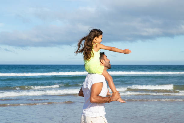 istock Excites little daughter sitting on fathers neck 1276407329