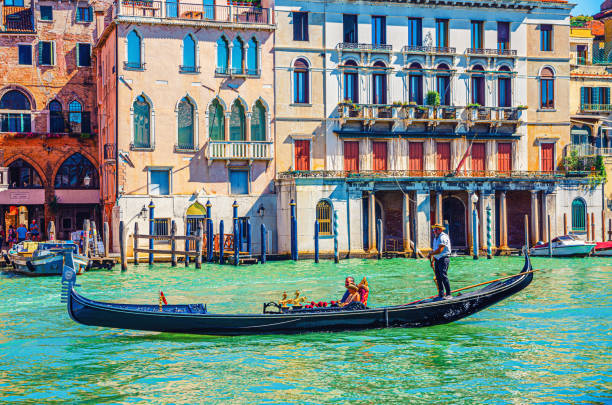Venice cityscape with Grand Canal waterway Venice, Italy, September 13, 2019: gondolier and tourists on gondola traditional boat sailing on water of Grand Canal waterway with Venetian architecture typical colorful buildings background gondola traditional boat photos stock pictures, royalty-free photos & images