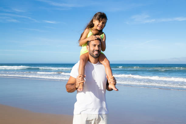 istock Happy little girl riding on dads neck 1276407615