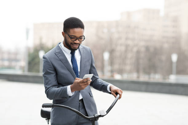 istock Handsome businessman texting on phone holding his bike 1276407616