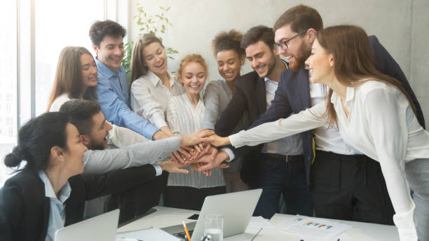 istock Teambuilding concept. Happy coworkers joining hands together 1276407714
