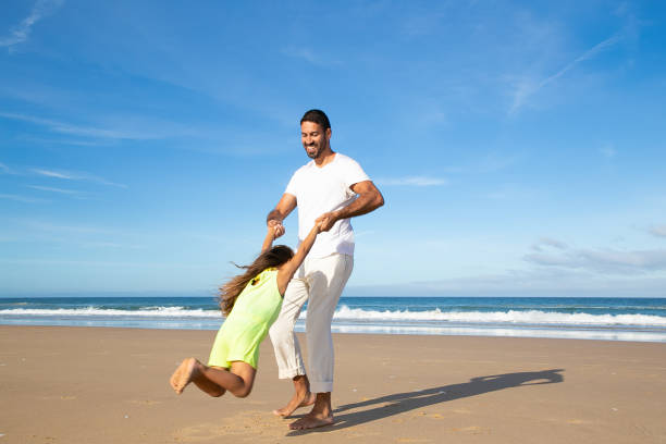 istock Joyful dad and daughter having fun on beach 1276408105