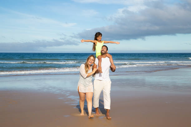 istock Happy parents and kid spending leisure time on beach 1276409197