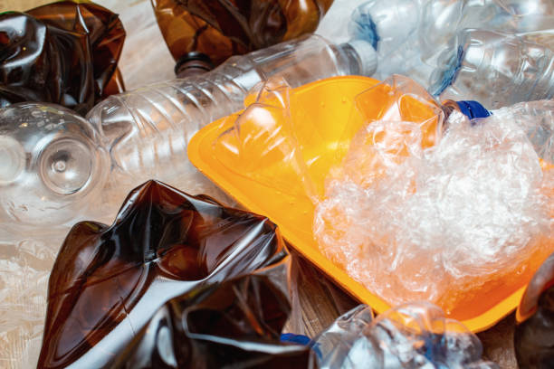 istock Lot of used plastic, crumpled empty bottles, packets, plastic orange dish, diaper, pollution recycle eco concept background close up selective focus 1276411559