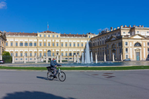 Royal Villa, Monza A senior man riding a bicycle in front of Villa Reale, Monza, Italy fountain courtyard villa italian culture stock pictures, royalty-free photos & images
