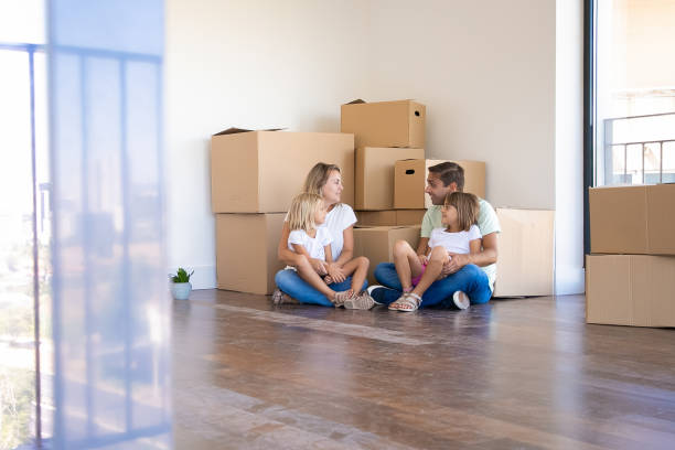 istock Husband, wife and their daughters sitting on floor 1276414446