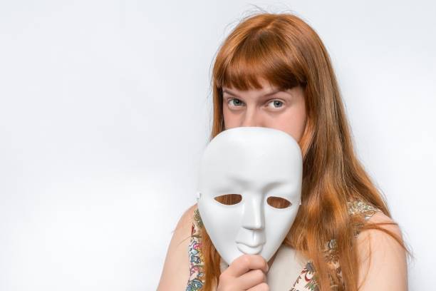 istock Mysterious woman cover her face behind a mask 1276417821