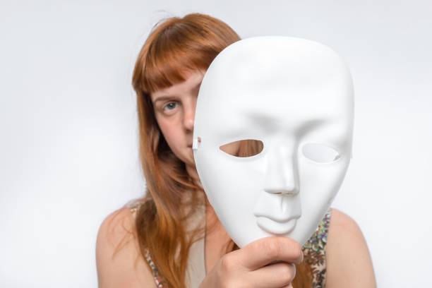 istock Mysterious woman cover her face behind a mask 1276417827