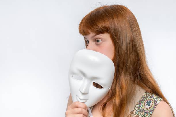 istock Mysterious woman cover her face behind a mask 1276417909