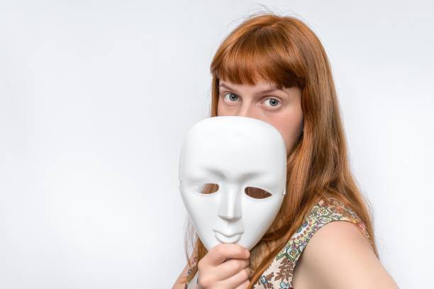 istock Mysterious woman cover her face behind a mask 1276417963