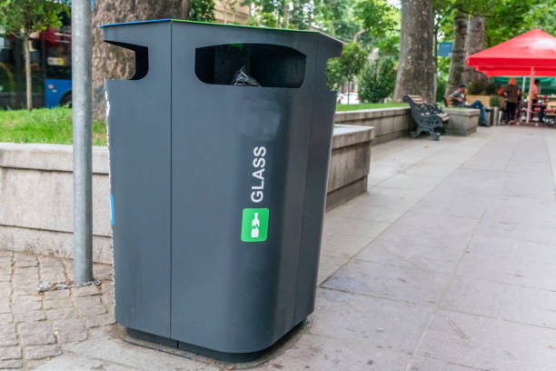 istock Glass Container Foreground. Black plastic trash bins for separate collection and sorting of paper and glass trash to protect the environment. 1276421542
