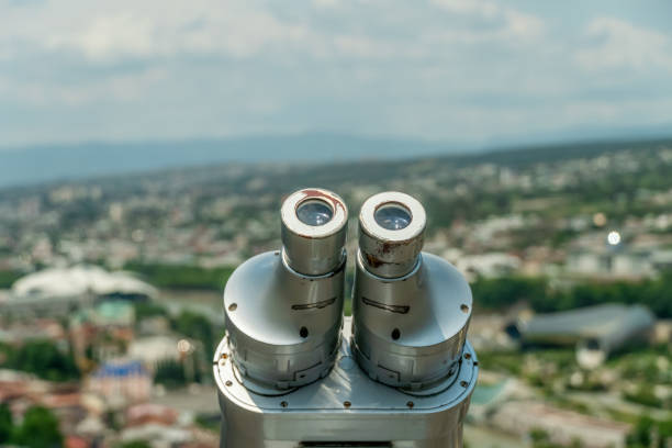 los binoculares de cerca con vistas a tiflis, la capital georgiana en el fondo en un día soleado. dispositivo gris para hacer turismo, visualización estacionaria de prismáticos, ver prismáticos con aceptador de facturas. - binoculars watching optical instrument closed fotografías e imágenes de stock