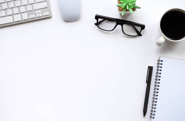 istock Top view above of White office desk table with keyboard, notebook and coffee cup with equipment other office supplies. Business and finance concept. Workplace, Flat lay with blank copy space. 1276421923