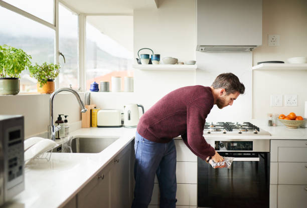 istock Young man standing in his kitchen drying his hands with a towel 1276422791