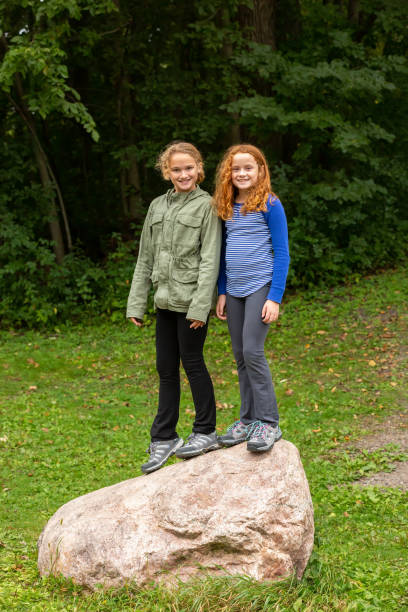 istock Two Girls Standing Together on Large Rock 1276423269