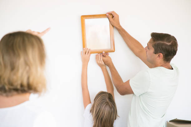 istock Father and daughter hanging up frame with copy space 1276424560
