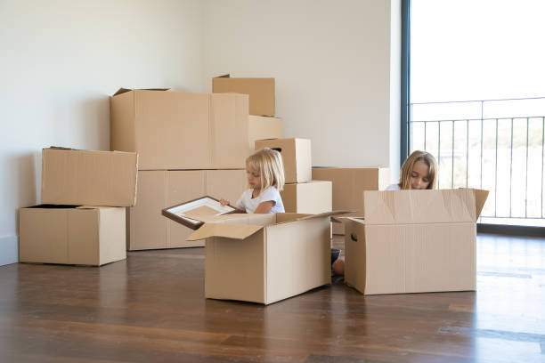 istock Focused little kids unpacking things in new apartment 1276426439