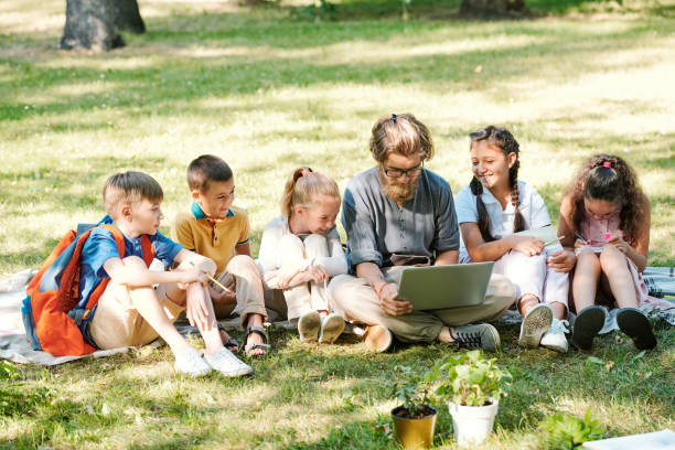 istock Teacher preparing project with schoolchildren in park 1276426785