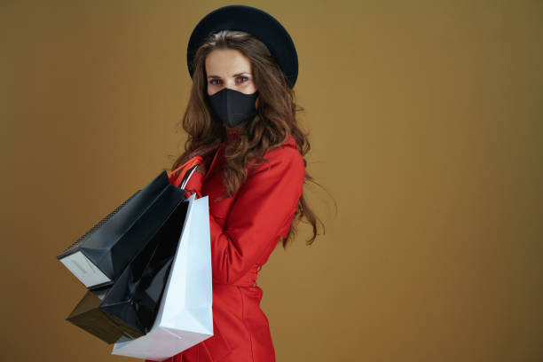 istock woman in coat isolated on bronze background 1276428380