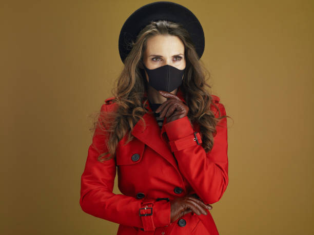 istock pensive elegant woman in coat isolated on beige 1276428455
