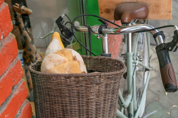 istock Bread in a wicker basket on a bicycle near a brick wall close-up 1276428591