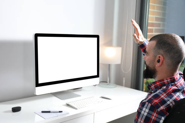 istock Young man waving to camera on video call from home office 1276429824