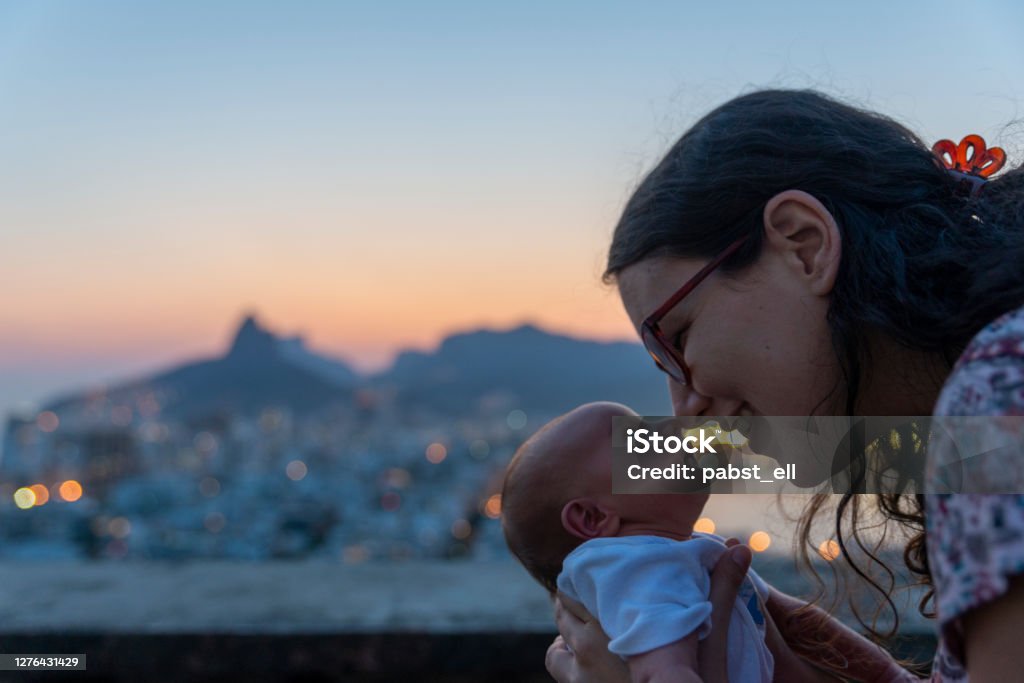 Mother rubbing nose with baby daughter Rio de Janeiro Mother and baby daughter touching nose with nose with Rio de Janeiro skyline on the background Rio de Janeiro Stock Photo