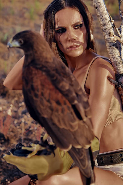 istock Beautiful woman posing on nature with eagle 1276431547