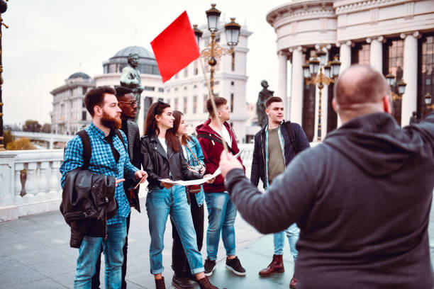 istock Tour Guide Explaining City Landmarks To Tourist Group 1276438232