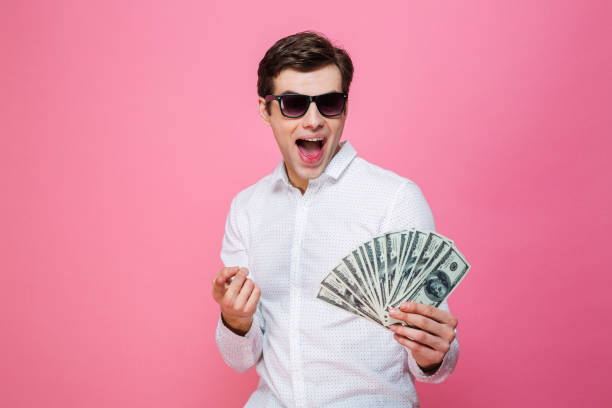 istock Young excited man holding money pointing. 1276438325