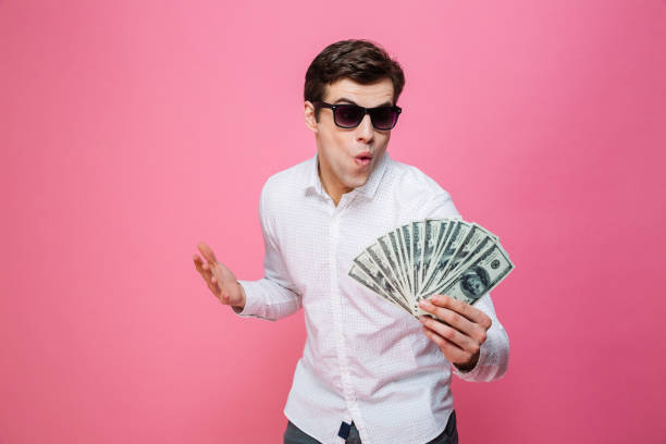 istock Excited man holding money. 1276438595