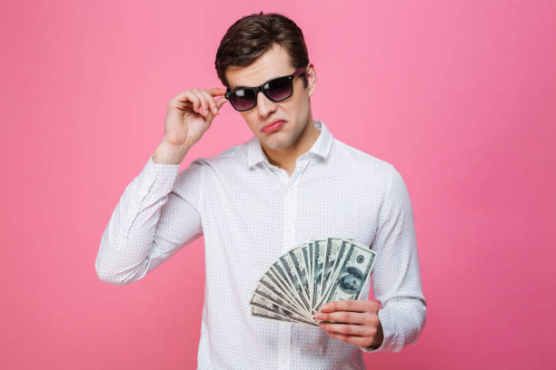 istock Serious handsome man wearing sunglasses holding money 1276438949