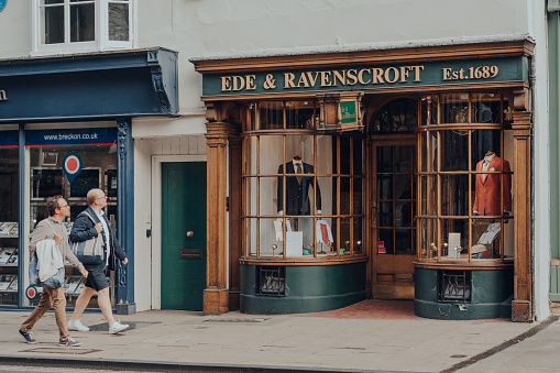 Oxford, UK - August 04, 2020: Exterior of closed Ede & Ravenscroft shop in Oxford, a city in England famous for its prestigious university, established in the 12th century. People walking past.