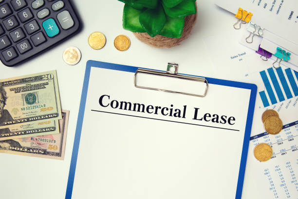 Paper with Commercial Lease on the table, calculator and glasses stock photo