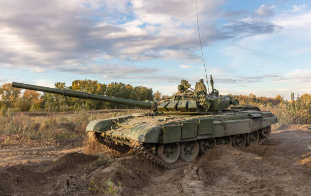 un colpo laterale del carro armato russo che gira t-64 sul campo. cielo nuvoloso blu come sfondo. - russian shot foto e immagini stock