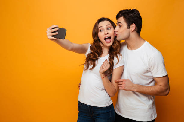 istock Young lovely couple posing together while making selfie on smartphone 1276446341
