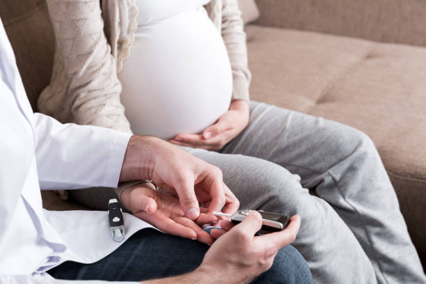 il giovane medico sta controllando la glicemia della donna incinta a casa - human pregnancy obgyn women child foto e immagini stock