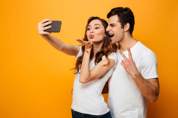 istock Funny young lovely couple posing together while making selfie 1276448059