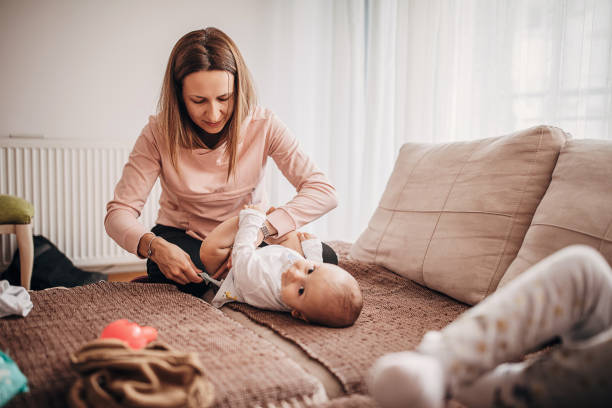 istock Mother changing diaper to a baby son on sofa at home 1276448614