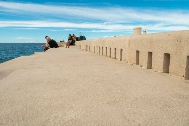 menschen sitzen an der meeresorgel, einer architektonischen klangkunst in zadar, kroatien. - sea passage audio stock-fotos und bilder